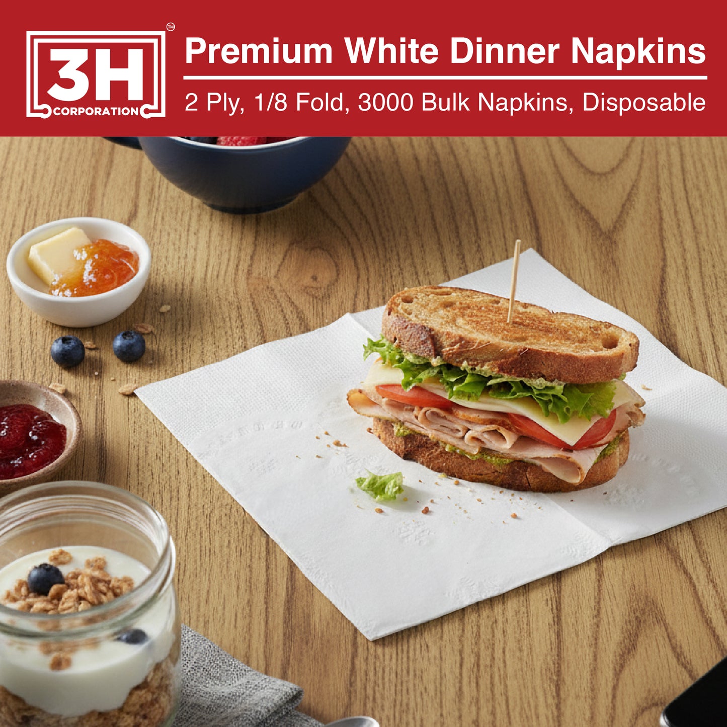 Disposable sandwich on a 3H branded napkin with breakfast items on a wooden table